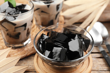 Tasty herbal jelly with milk and mint served on wooden table, closeup
