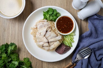 Chicken and rice with coriander and cucumber with sauce and soup in a white plate, hainanese chicken rice, thai called khao man gai, asian food, thai food