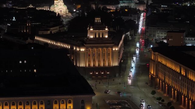 Drone reveal of Sofia&rsquo;s glowing central road, capturing night traffic and the illuminated Alexander Nevsky Cathedral rising in the background