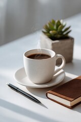 Steaming coffee cup with notebook, pen, and succulent on a table.