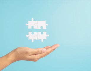 Harmony and Connection: A hand delicately presents a pair of puzzle pieces, symbolizing unity, completion, and the interconnectedness of ideas.