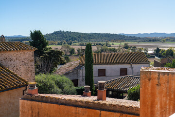 View to a medieval Spanish buildings in a village and mountains from the terrace of the villa. Luxury and calm leisure option close to Barcelona. Slow morning concept.