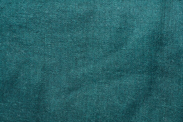 Close-up of teal fabric with a woven texture, perfect for backgrounds