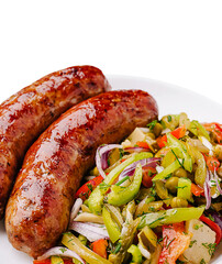 Grilled sausages served with colorful mixed vegetables on a white plate