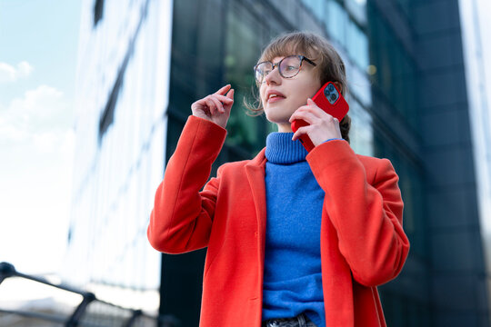 Woman talking on her phone outside modern buildings during a sunny day