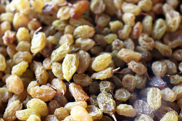 Raisins close up showing detailed dried grapes with natural golden texture filling entire frame