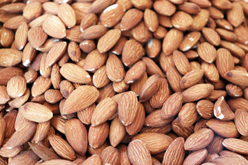 Almonds extreme close up showing dense pile of raw nuts with detailed textured surface