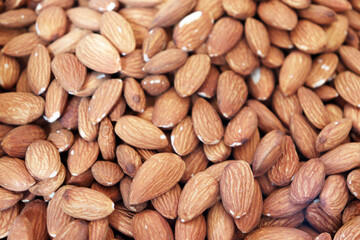 Almonds extreme close up showing dense pile of raw nuts with detailed textured surface