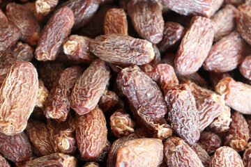 Dates extreme close up showing dense pile of dried fruits with deep wrinkled texture