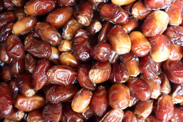 Dates extreme close up showing glossy fresh fruit with rich reddish brown textures
