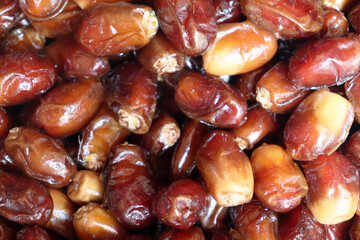 Dates extreme close up showing glossy fresh fruit with rich reddish brown textures