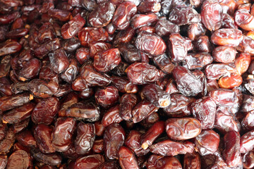 Dates extreme close up showing glossy dark burgundy fruit with rich textures