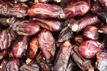 Dates extreme close up showing glossy dark burgundy fruit with rich textures