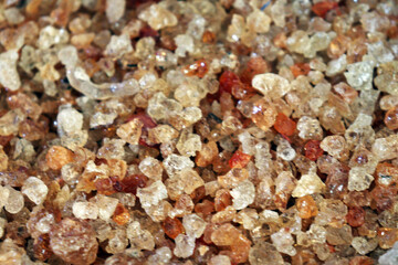 Close up of natural gum arabic resin granules with sparkling texture and golden color