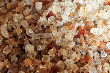 Close up of natural gum arabic resin granules with sparkling texture and golden color
