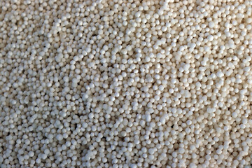 Close up of raw tapioca pearls filling frame with smooth texture and bright white color