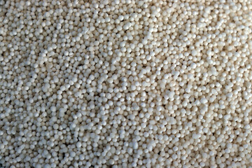 Close up of raw tapioca pearls filling frame with smooth texture and bright white color