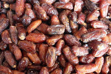 Dates extreme close up showing glossy dark burgundy fruit with rich textures