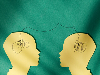 Two human silhouettes connected by a line between their heads, symbolizing empathy, emotional connection, communication, understanding, and interpersonal relationships, 