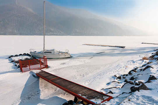 jacht w zamarzniętym g&oacute;rskim jeziorze podczas srogiej zimy