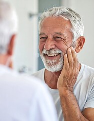 Senior man smiling in bathroom mirror