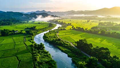 Aerial view of a river snaking through lush green fields toward rolling hills under a warm, bright sky
