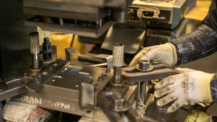 Hands Adjusting Metal Fixture in Industrial Manufacturing Process