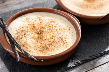 Creamy homemade Spanish custard served in a bowl on wooden table