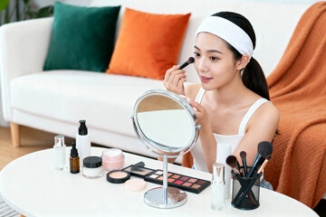 Young Woman Applying Makeup at Home Vanity Table