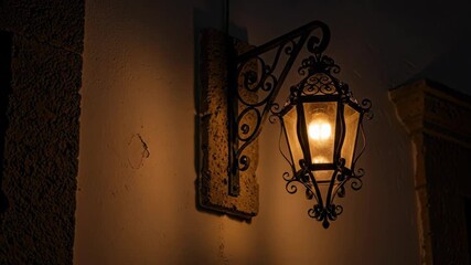 Elegant iron lantern illuminates rustic wall with warm glow at twilight - Powered by Adobe