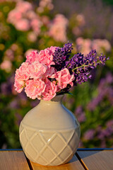 różowe róże i fioletowa lawenda w wazonie na rozmytym tle, róże i lawenda w małym wazonie na tle ogrodu, pink roses and purple lavender in a vase on a blurry background  © kateej