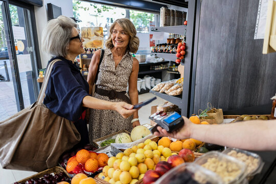 Senior women making contactless payment in grocery store