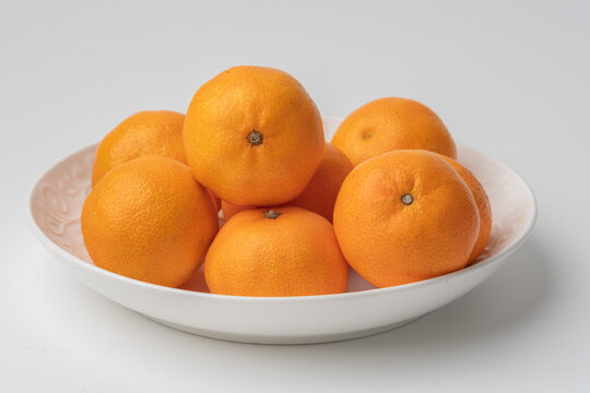 tangerines in a white plate - Powered by Adobe
