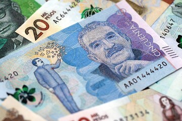 Colombian pesos money bills banknotes lies in big pile on table close up. Concept of finances and business in Colombia