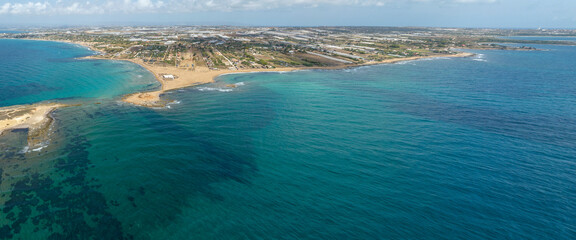 Obraz premium Aerial view of the Sicilian coast. There is a long sandy beach overlooking the Mediterranean Sea. It is located in the municipality of Portopalo, in the province of Syracuse, Sicily, Italy.