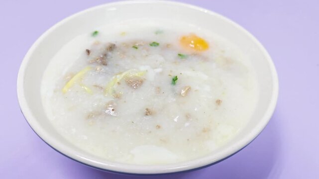 Rice porridge or congee with pork egg sliced ginger and vegetable. Delicious breakfast.