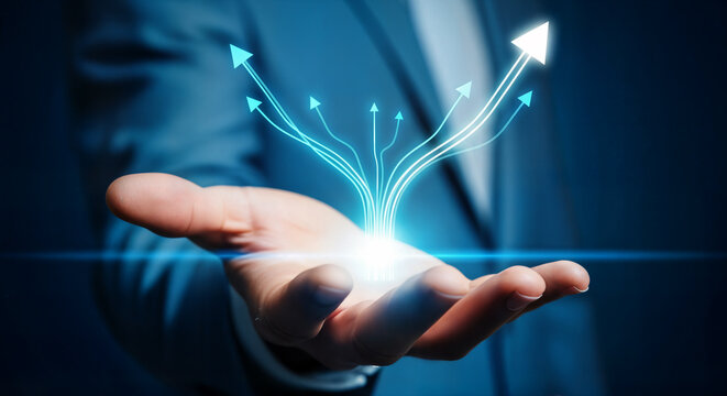 Businessmans hand holding a glowing digital projection of arrows symbolizing growth and success