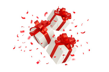 Obraz premium christmas gift boxes with red ribbon and confetti flying isolated on white 