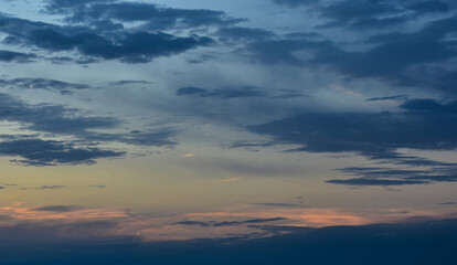 Serene sunset sky spreading warm magical colors over floating gentle clouds