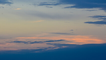 Vibrant sunset sky shining warmly through delicate clouds in a peaceful evening