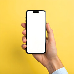 Hand holding smartphone with blank screen on yellow background