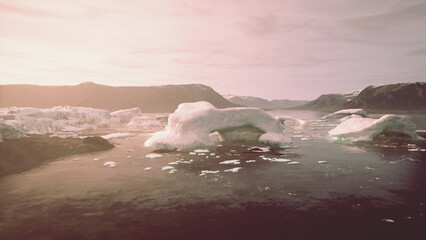 Icebergs drift slowly in tranquil waters as the sun sets behind distant mountains, casting warm hues across the serene landscape, creating a breathtaking and peaceful scene. © icetray