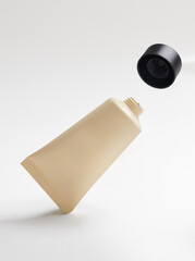 The cap of the cream container burst out. Cream container  isolated in white background