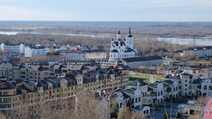 A view of Tobolsk from a hill. Houses, a church, and a forest on the horizon. Autumn.
