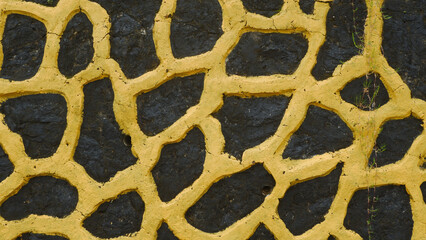 Abstract Textured Wall with Yellow Pattern on Dark Stone Surface