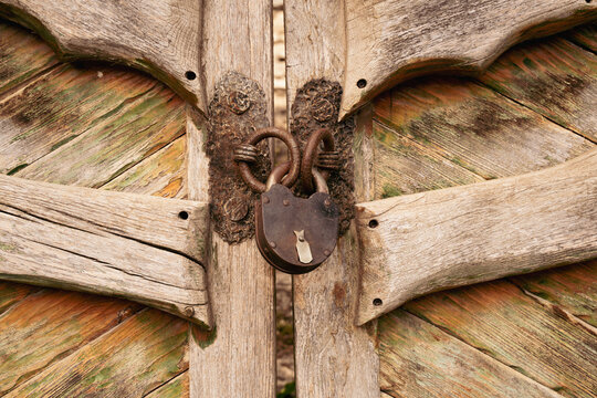 Rustic wooden gate with weathered texture and antique iron lock