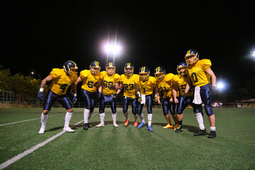 American football players posing as a team on the illuminated night field