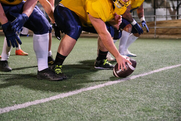 American football player placing ball on field for game start