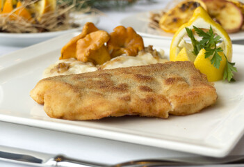 Christmas fried fish in breadcrumbs with chanterelle mushrooms and dumplings