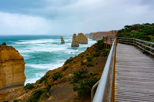 Walkway and the Twelve Apostles rocks formation at Port Campbell National Park in rainy day, Victoria, Australia. - Powered by Adobe